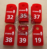 Номерки для ключей №30 для фитнес студии. Материал номерков - красный акрил. Нанесение номера и логотипа "studio" - гравировка с белой прокраской.
